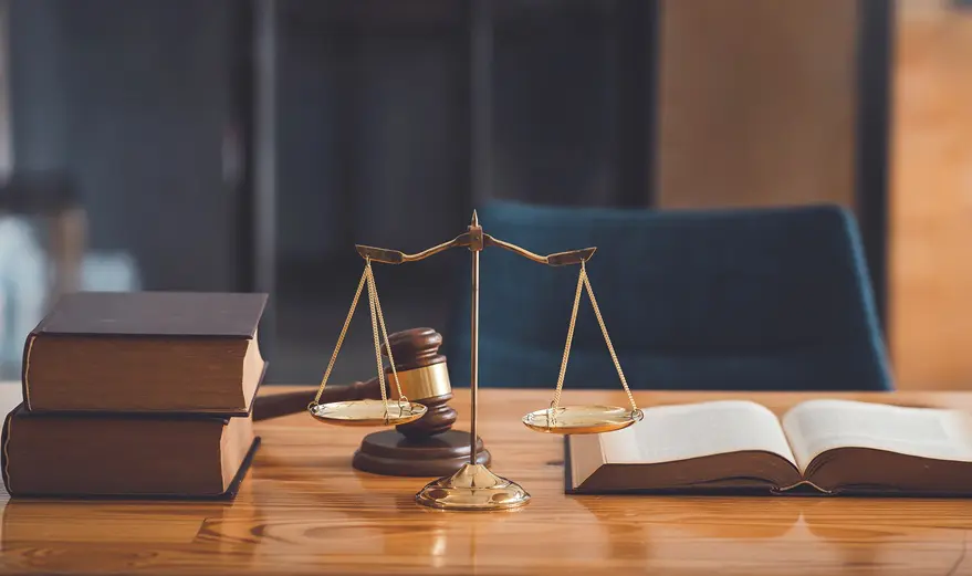 A wooden table with two books and a gavel on it.