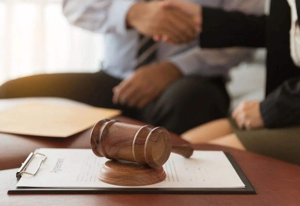 A judge 's gavel sitting on top of papers.