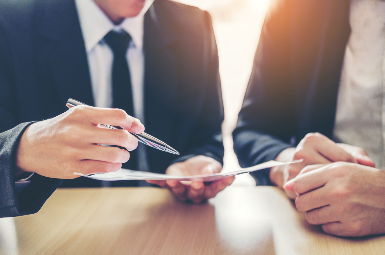 Two men in suits are sitting at a table