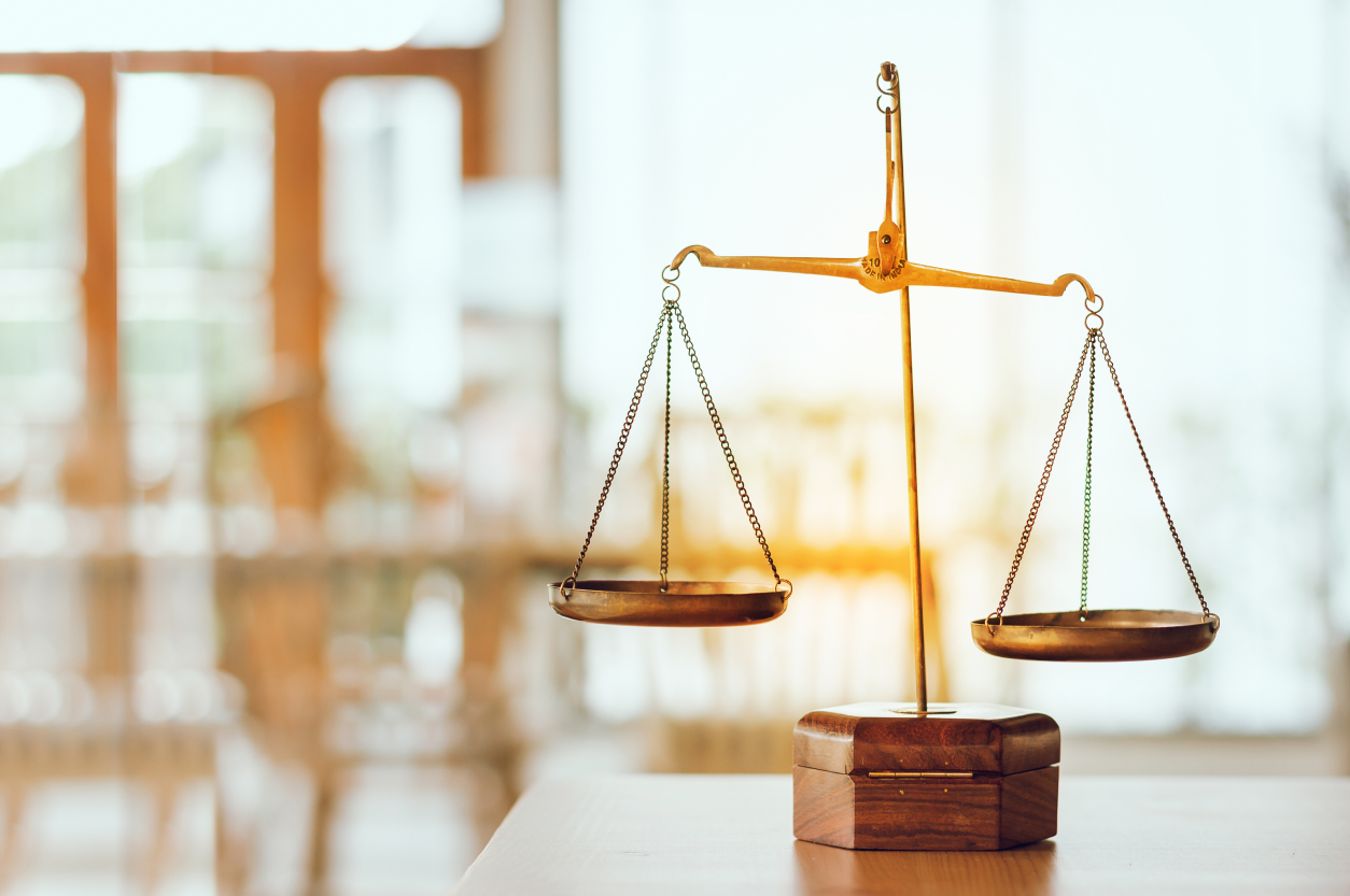 A wooden table with two scales on top of it.